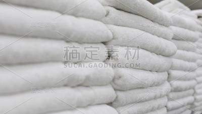 白色毛巾整齐地排列在架子上。酒店、水疗中心、游泳池和淋浴间的清洁毛巾