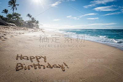 “生日快乐”写在沙滩上，用波浪冲刷着