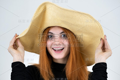滑稽的红发女人在包黄色草帽肖像。
