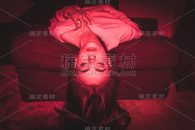 年轻女子头朝下躺在沙发上