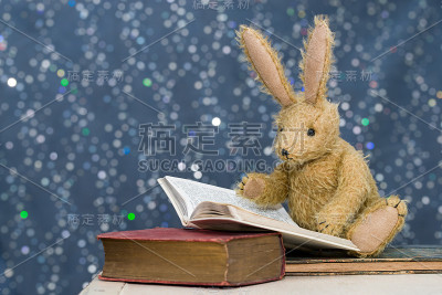 可爱的孩子的玩具兔子在故事时间阅读。