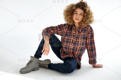 金发卷毛的年轻女子面带微笑，穿着棉格子衬衫