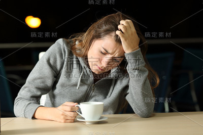 一个悲伤的少年晚上在咖啡店里抱怨