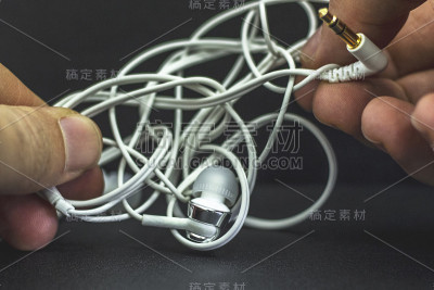 有线耳机，其中的电缆是缠结。黑色背景。