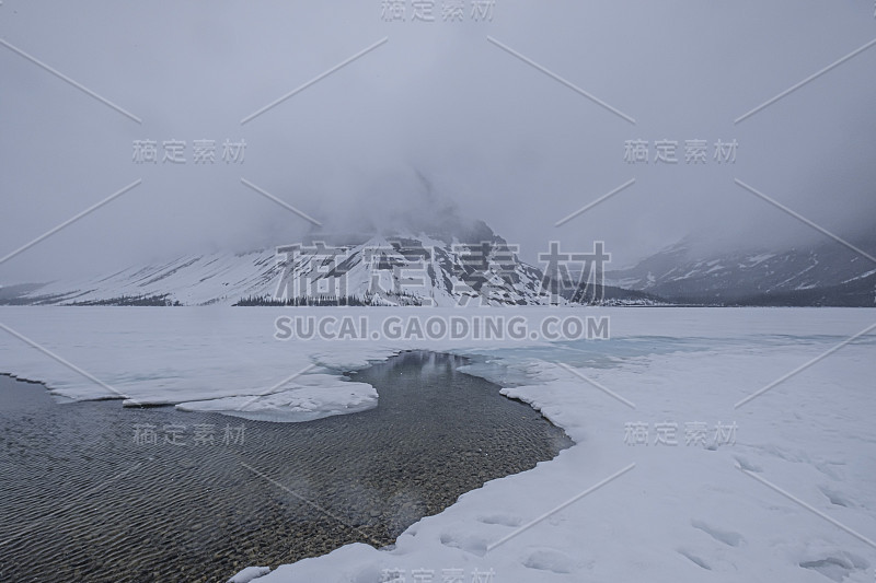 加拿大贾斯帕，一个宁静的湖，周围群山被雪覆盖