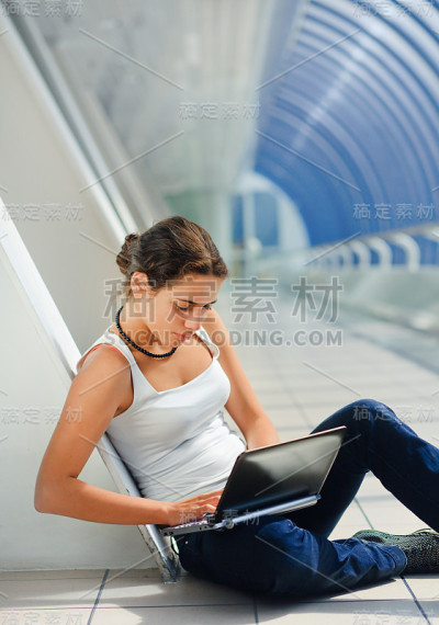 一个小女孩坐在电脑旁边