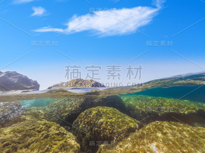 在一个晴朗的日子，阿尔盖罗岩石海岸的分裂水下视图