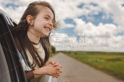 一个孩子在旅行时从开着的车窗里做梦。暑假与家人旅行