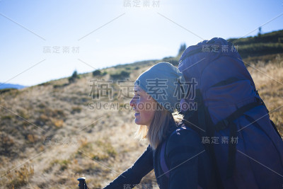 她旅行时背着背包。