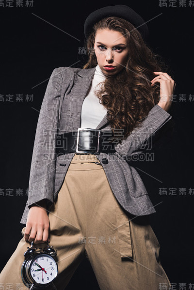 女人拿着钟，看着相机