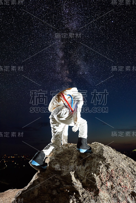 宇航员在星空下爬山。