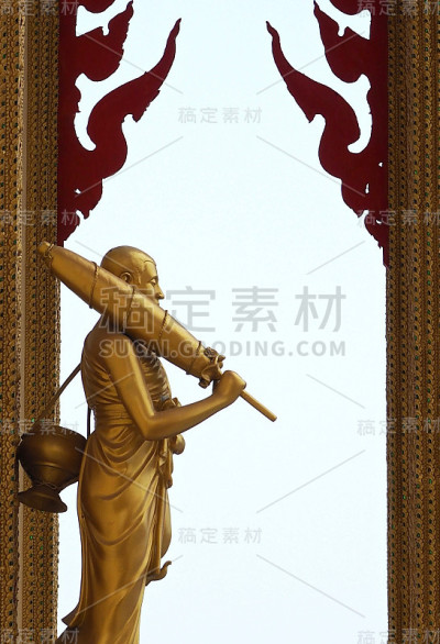 和尚塑像带着伞和碗行走。