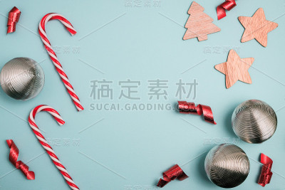 圣诞节冬季组成。银色的球和红色的丝带，蓝色的背景是糖果手杖。俯视图，平放