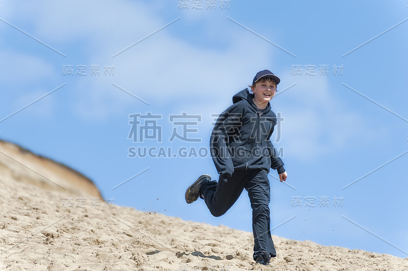 男孩在俄勒冈海岸太平洋城的沙丘山上玩耍