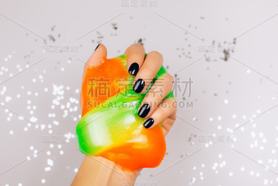 有黑色指甲的手拿着粘液