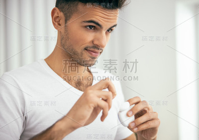 微笑的年轻人拿着牙线在房间里
