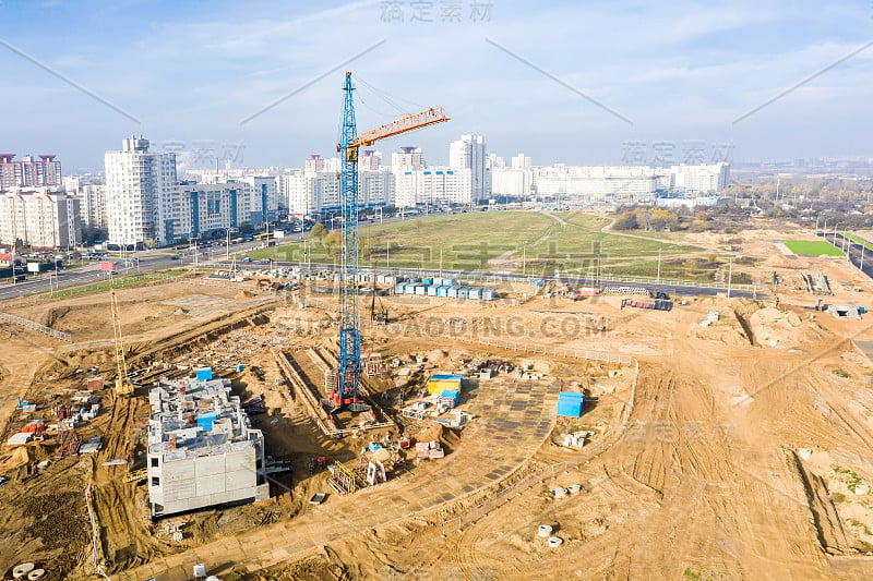 蓝天下的起重机和在建建筑。鸟瞰图