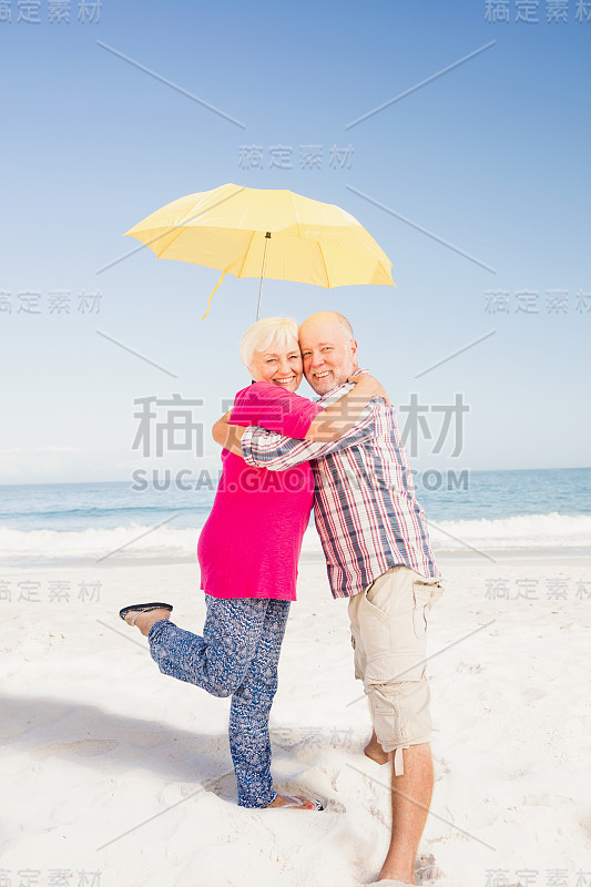 老夫妇拥抱着，撑着伞