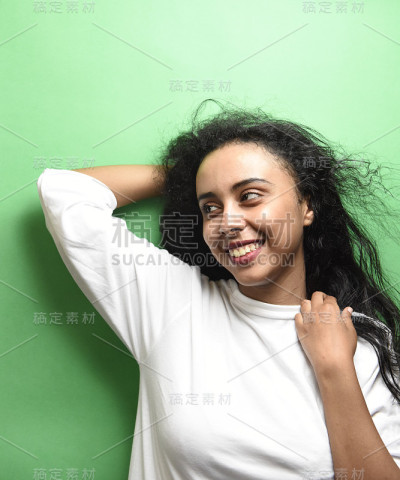 有着一头黑发的中东年轻女子。室内照片的奇妙女性模特在绿色的背景。