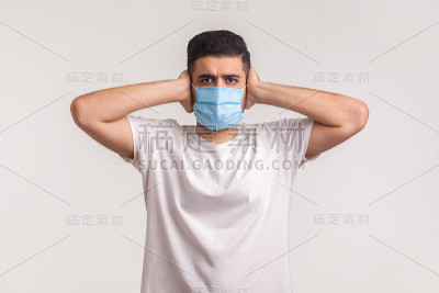 预防冠状病毒、传染性疾病。男子捂住耳朵，戴上卫生安全口罩