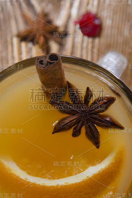 Top view on a glass with orange mulled wine with p