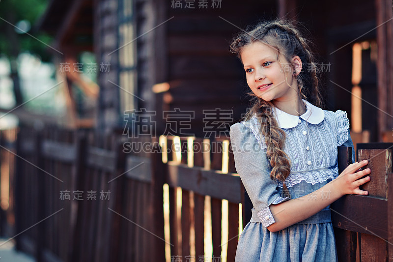 穿着复古服装的女孩，背景是一所乡村木屋