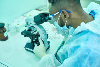 医学实验室中使用显微镜的科学家