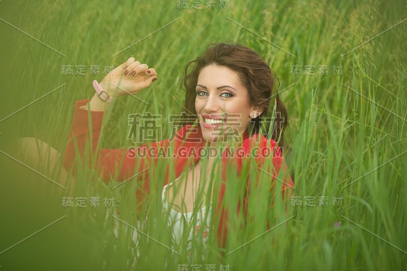 漂亮的黑发长卷发的欧洲女孩特写肖像户外在夏天的绿色公园。