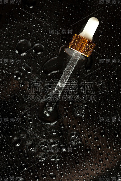 药滴在黑色玻璃背景与飞溅和水滴