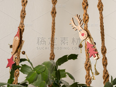 一个晒衣夹，上面有一只麋鹿，挂在一个打结的吊篮上