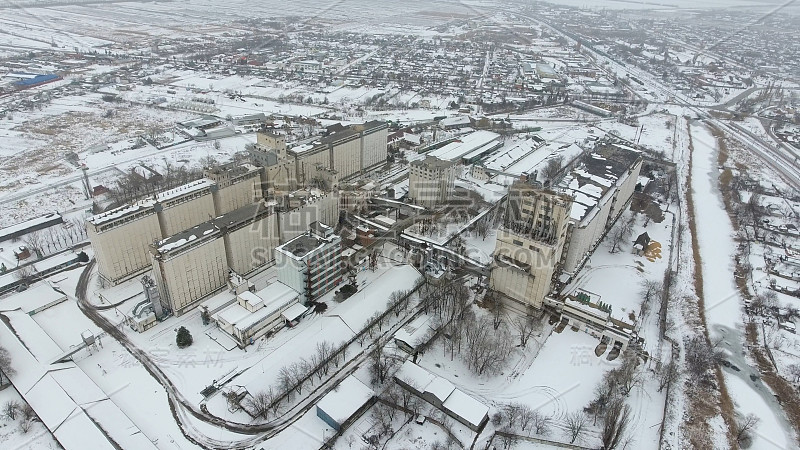 谷物在冬季终了。农村地区被雪覆盖的粮食升降机。干燥和储存谷物的建筑物。