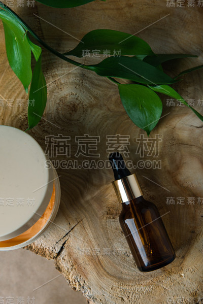 一罐奶油和一根玻璃管与绿色叶子在树上砍