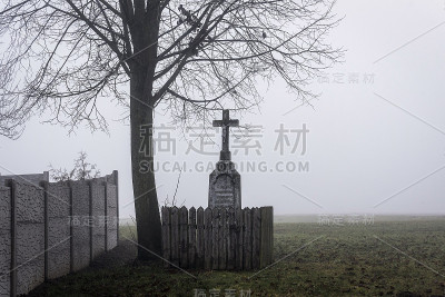 基督的折磨紧挨着墙下的树从雾中浮现