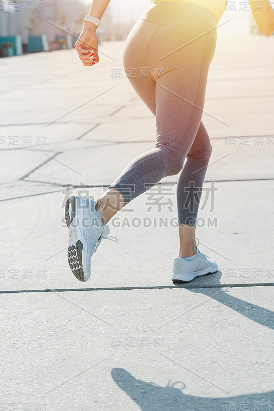 在户外人行道上跑步的女人。下半身裁剪的，下半身