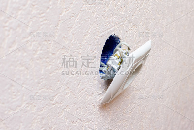 坏了的旧插座从墙上掉了下来