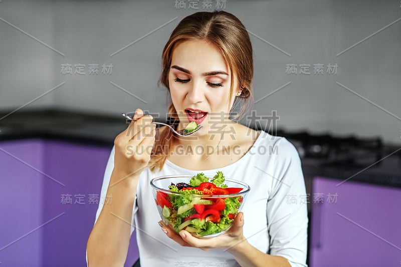 一位年轻女子吃着美味的蔬菜沙拉。其理念是健康饮食，素食主义，减肥。