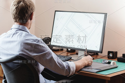 平面设计师使用数字平板电脑和电脑在办公室或