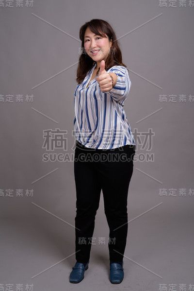工作室拍摄的成熟美丽的亚洲女商人在灰色的背景