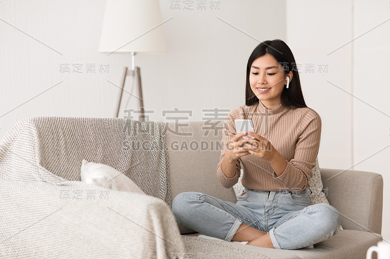 亚洲女孩戴着耳机听音乐，享受周末