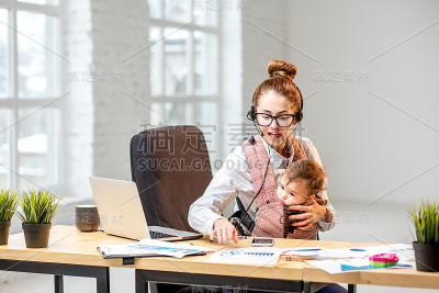 带着孩子在办公室工作的女商人