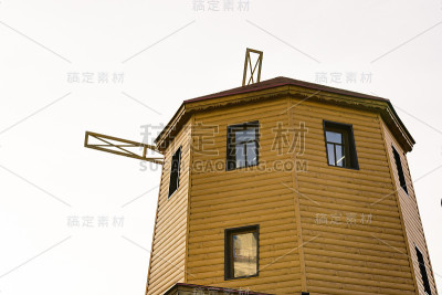 在天空的映衬下，一个质朴的古老的木制风车