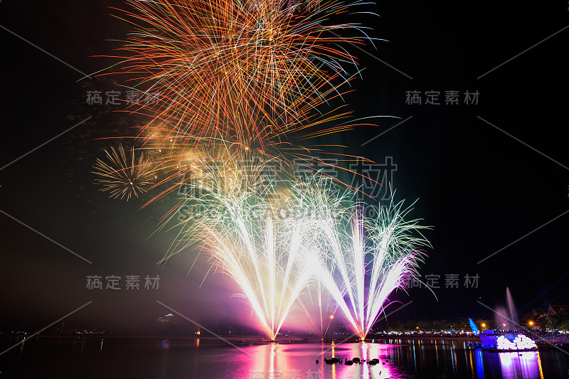 明亮多彩的烟花映衬着漆黑的夜空。烟花迎新年。