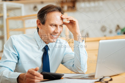 聪明快乐的男人微笑着看着笔记本电脑