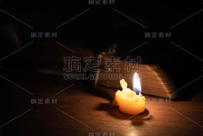 十字架，圣经和蜡烛放在一张旧橡木木桌上。
