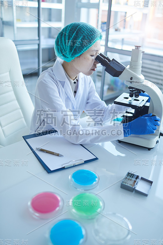 女性亚洲科学家使用显微镜