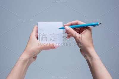 女人手里拿着笔记本和笔