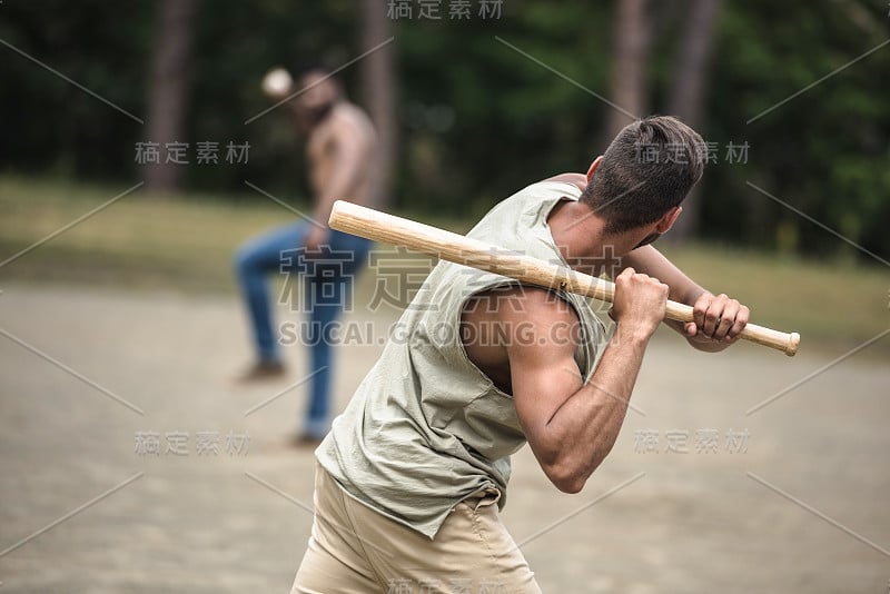 年轻的多民族男子在球场上打棒球，有选择性的焦点