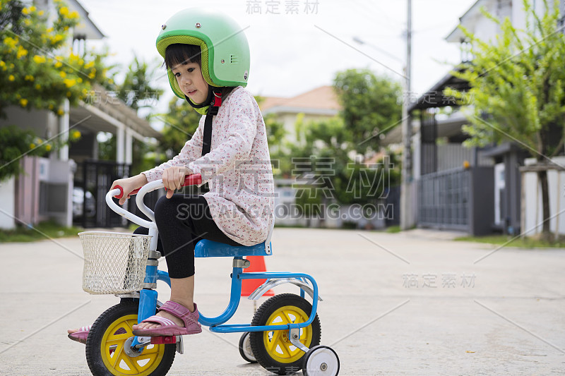 一个小女孩在她住的村子里学会了骑平衡自行车