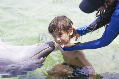 假期生活方式-快乐男孩拥抱海豚
