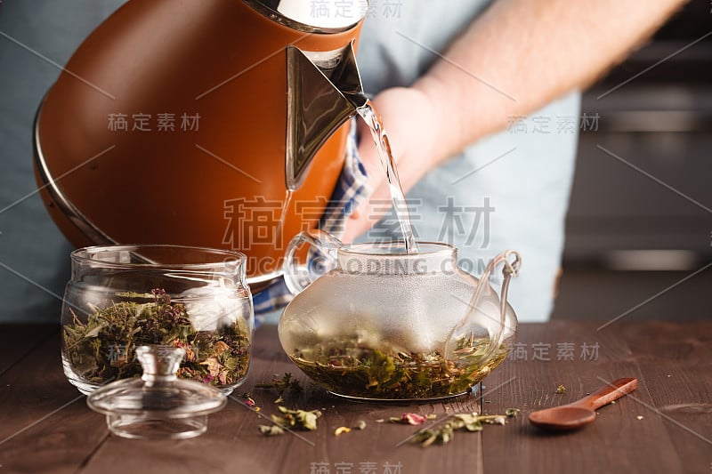 往玻璃杯里倒花草茶的人